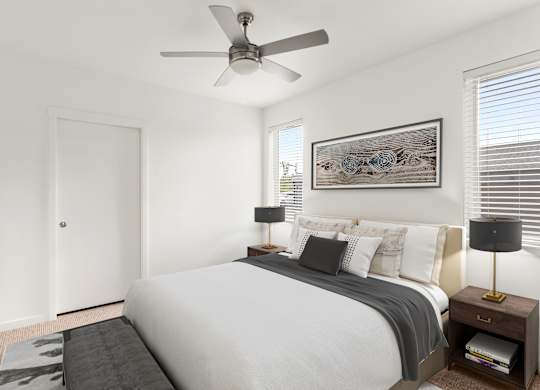 A bedroom with a bed, nightstand, and a ceiling fan.
