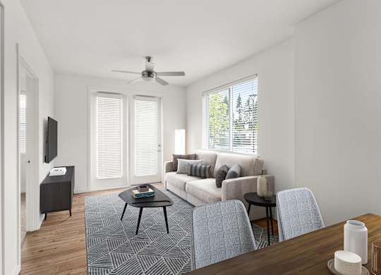 A living room with a couch, chairs, and a television.