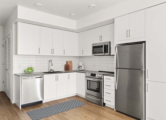 A modern kitchen with stainless steel appliances and white cabinets.