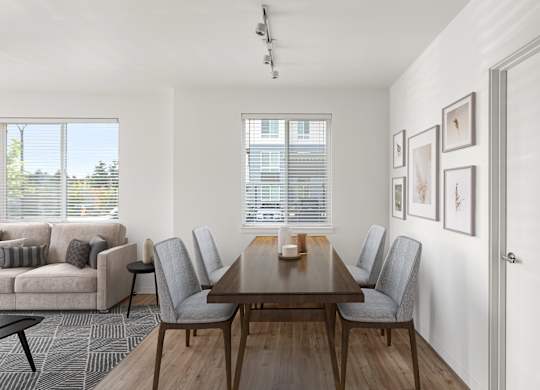 A dining room with a wooden table and grey chairs.