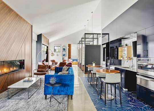 A modern living room with a fireplace and a blue couch.