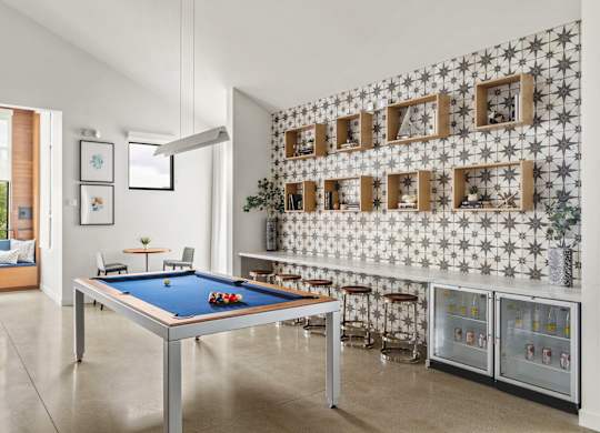 A pool table in a room with a wallpapered wall.