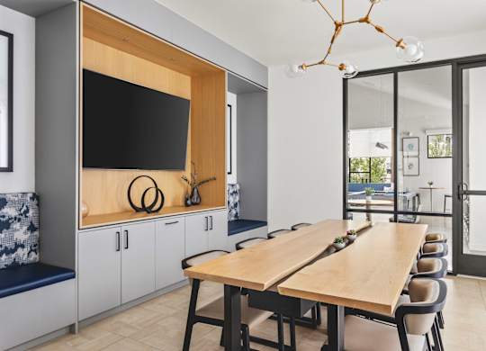 A modern dining room with a wooden table and chairs.
