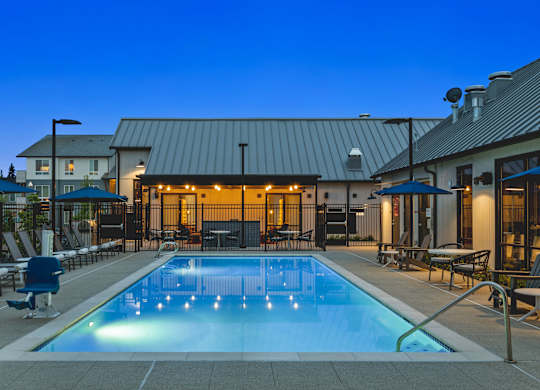 A swimming pool in a backyard with a building in the background.