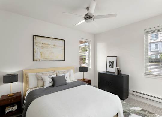 A bedroom with a bed, nightstand, and a painting on the wall.