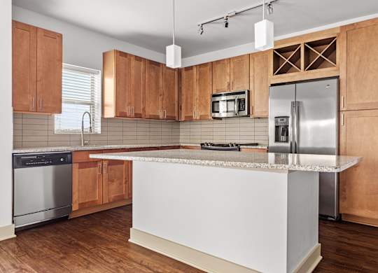 A kitchen with wooden cabinets and a white island.