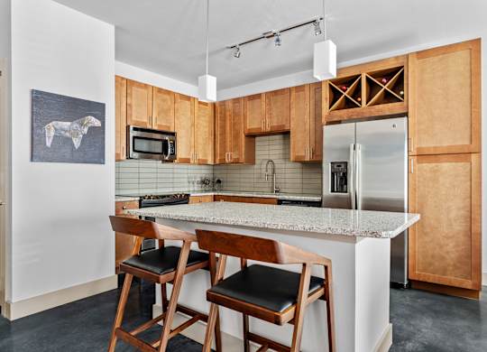 A kitchen with wooden cabinets and a marble countertop.