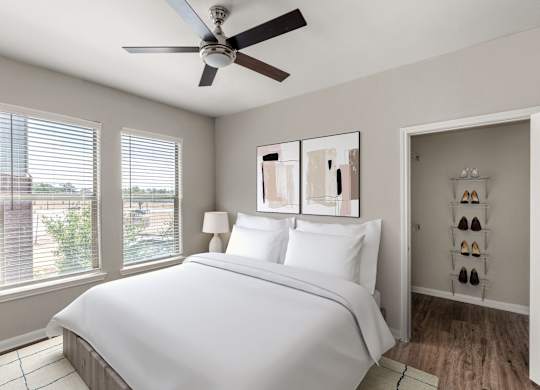 A bedroom with a large bed and a ceiling fan.