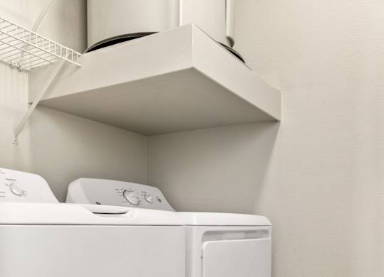 A white dryer and washer in a small laundry room.