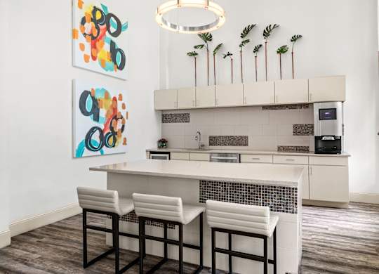 A kitchen with a white counter and bar stools.