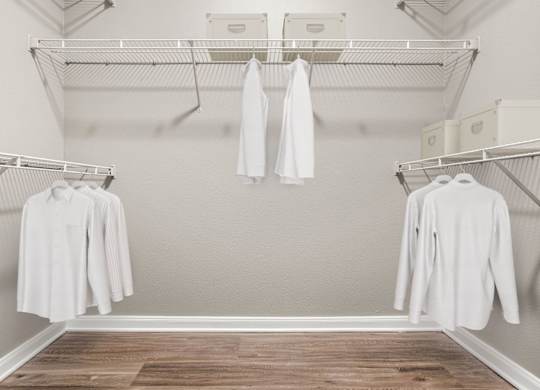 A white shirt is hanging on a clothes rack in a room.