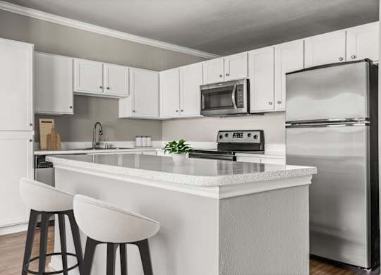 A modern kitchen with white cabinets and a white island.