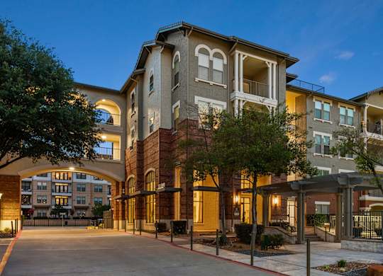 A large apartment complex with a courtyard and trees.