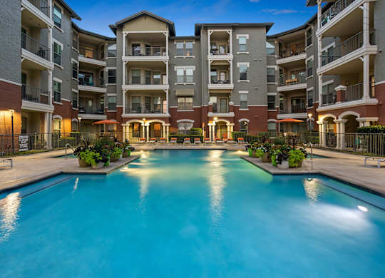 A large swimming pool in front of apartment buildings.