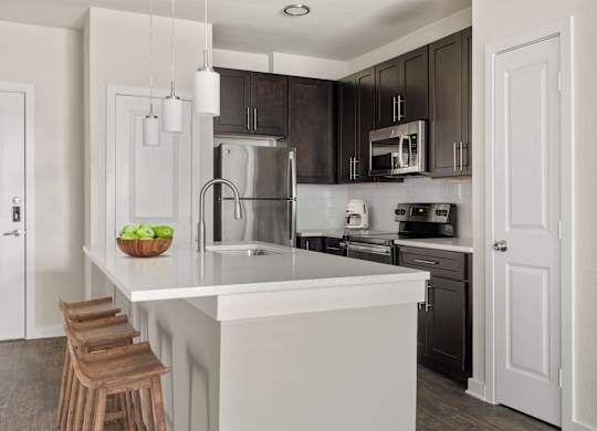 A kitchen with a white island and a refrigerator.