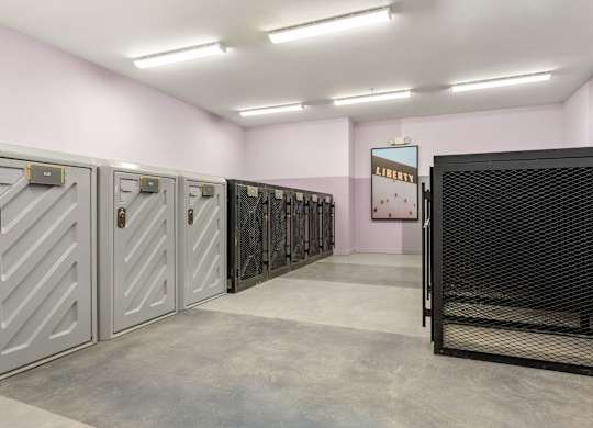 A row of metal safe deposit boxes in a pink room.