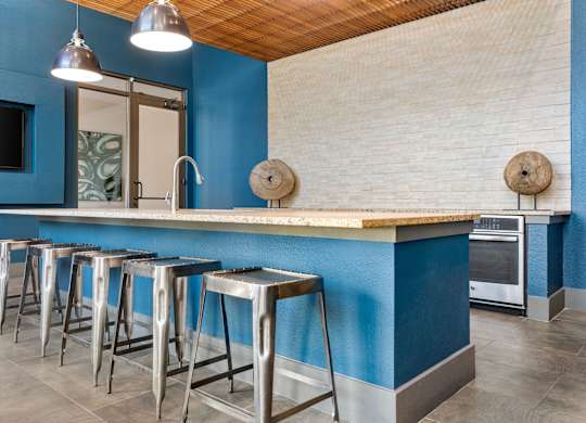 A kitchen with blue walls and a wooden ceiling.