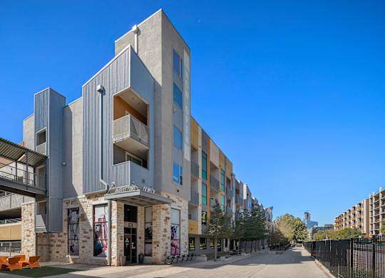 A modern building with a glass entrance and a metal railing.