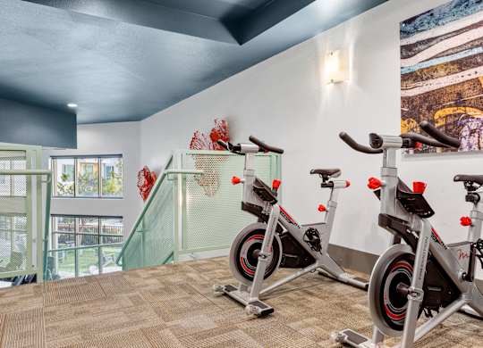 A room with a treadmill and a stationary bike.