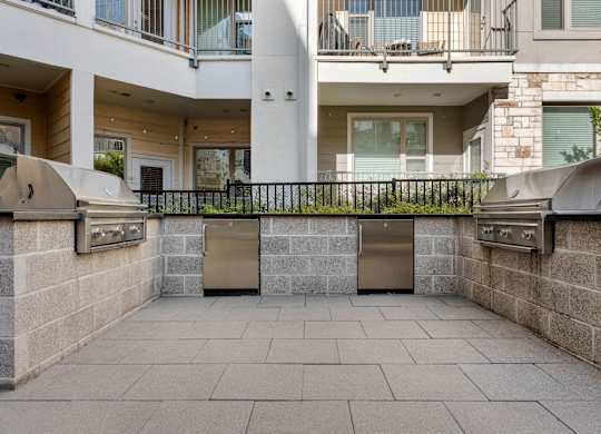 A courtyard with a black fence and a stone wall.
