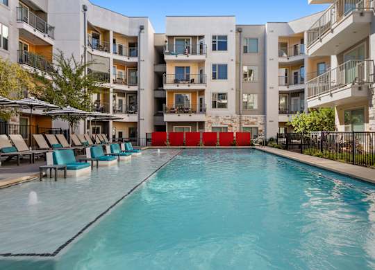 A swimming pool in front of apartment buildings.