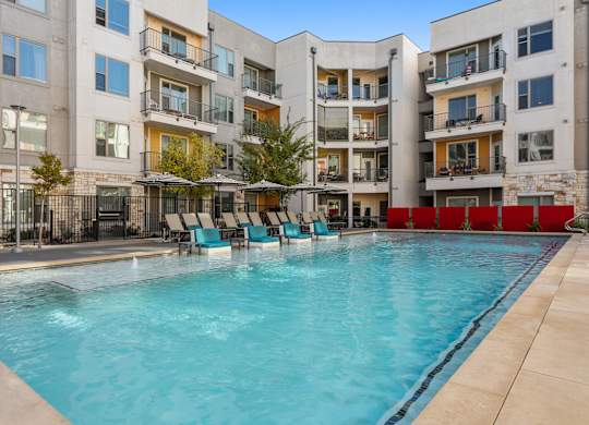 A swimming pool in front of a residential building.