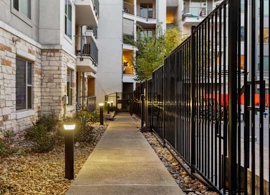 A black metal fence runs along the side of a sidewalk.