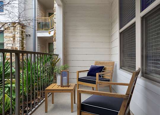 A wooden chair with a cushion sits on a patio.
