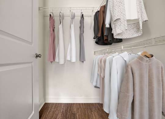 Clothes hanging on a rack in a room.