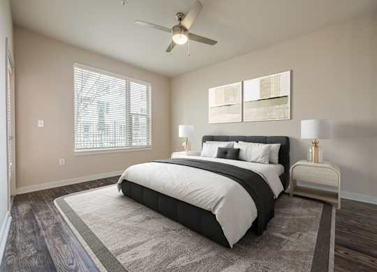 A bedroom with a large bed and a ceiling fan.