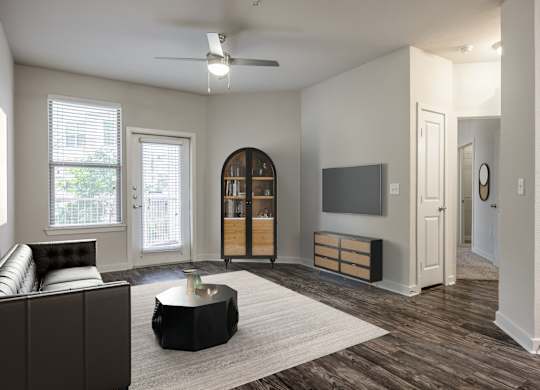 A living room with a brown couch and a white ceiling fan.