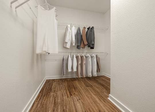 A white room with clothes hanging on a rack.