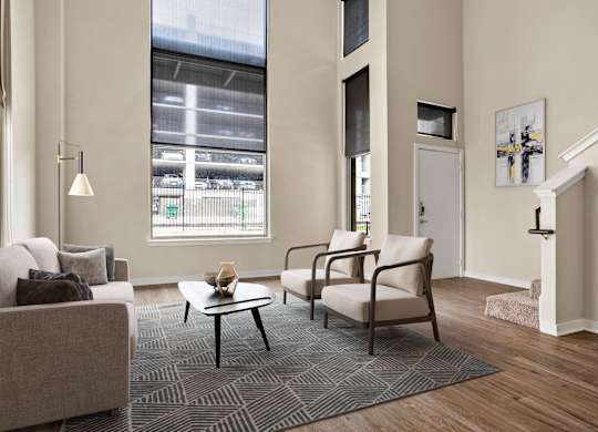 A living room with a grey sofa, a black coffee table and a chair.