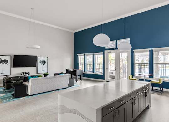 A modern kitchen with a large island and a living area with a sofa.