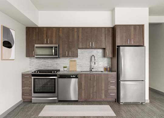A modern kitchen with a refrigerator, oven, and microwave.