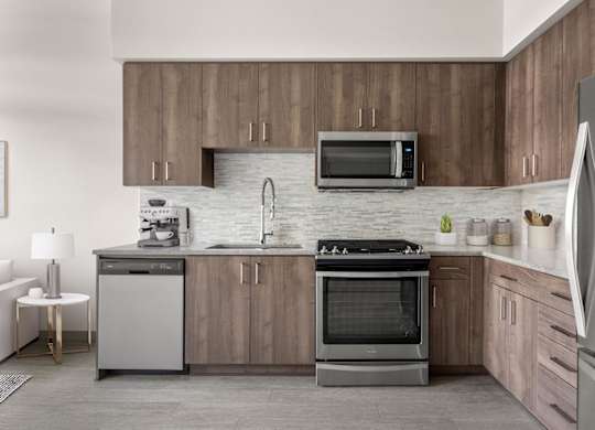 A modern kitchen with wooden cabinets and stainless steel appliances.