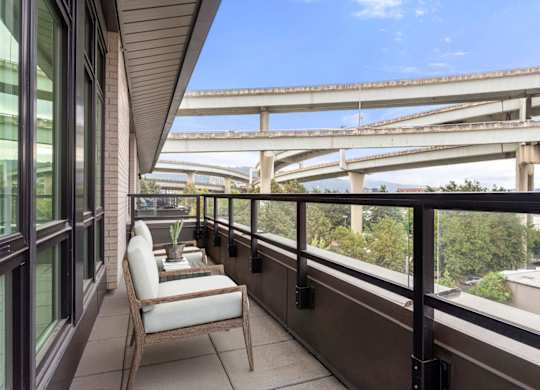 A chair is on a balcony overlooking a highway.