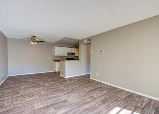 A room with wooden flooring and a ceiling fan.