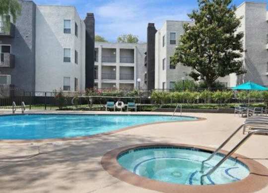 A swimming pool in front of apartment buildings.