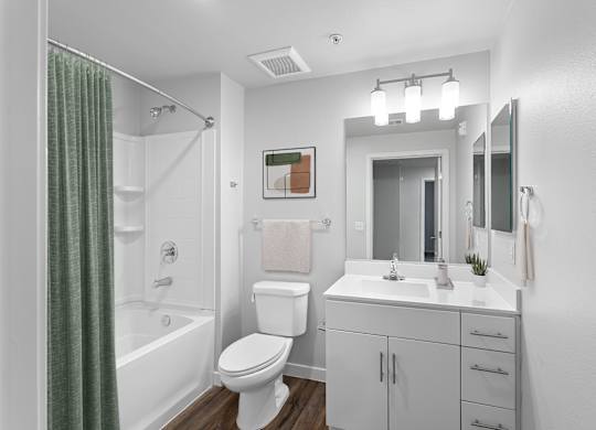 A white bathroom with a toilet, sink, and shower.