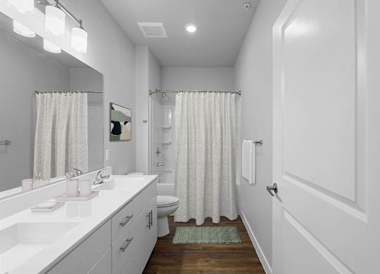 A white bathroom with a green rug on the floor.