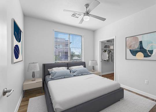 A bedroom with a bed, a ceiling fan, and two wall art pieces.