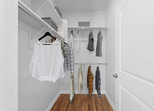 Clothes hanging on a rack in a white room.