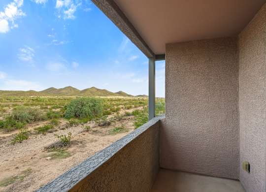 A desert landscape is visible from a balcony.