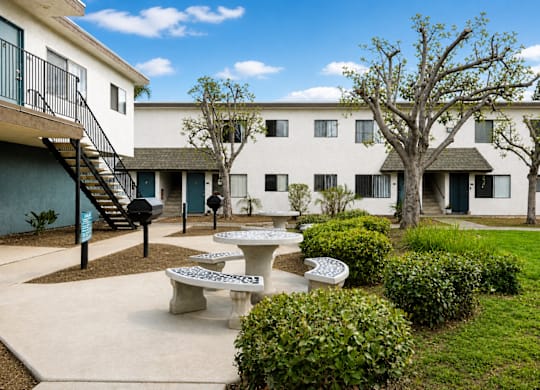 A courtyard with tables and chairs surrounded by buildings.