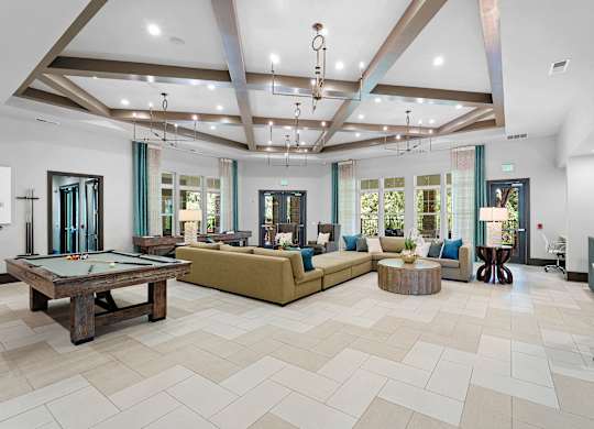 A large, well-lit room with a pool table and comfortable seating.