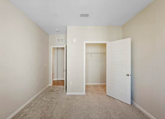 A room with a carpeted floor and two white doors.