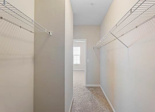 A long hallway with a carpeted floor and white walls.