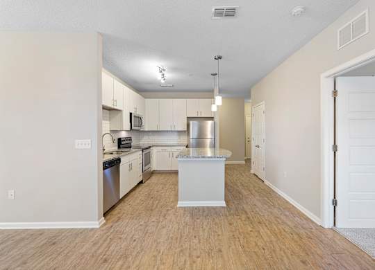 A kitchen with white cabinets and a white island.