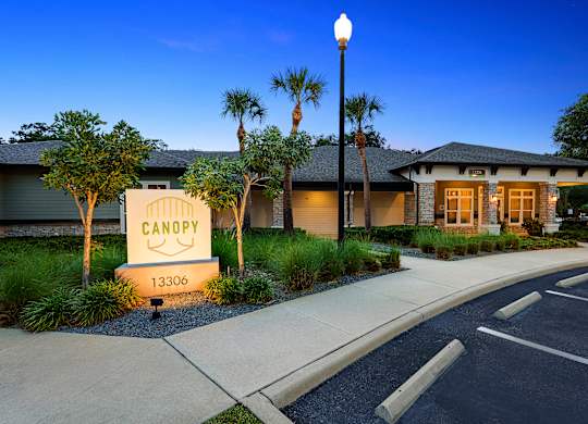The image shows a building with a sign that reads "CANOPY" and the address "13306" in front of it.